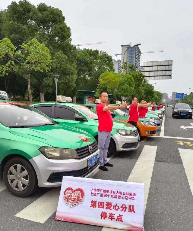 参与活动的爱心司机在现场纷纷合影留念,贴有上饶广播爱心车贴的送考