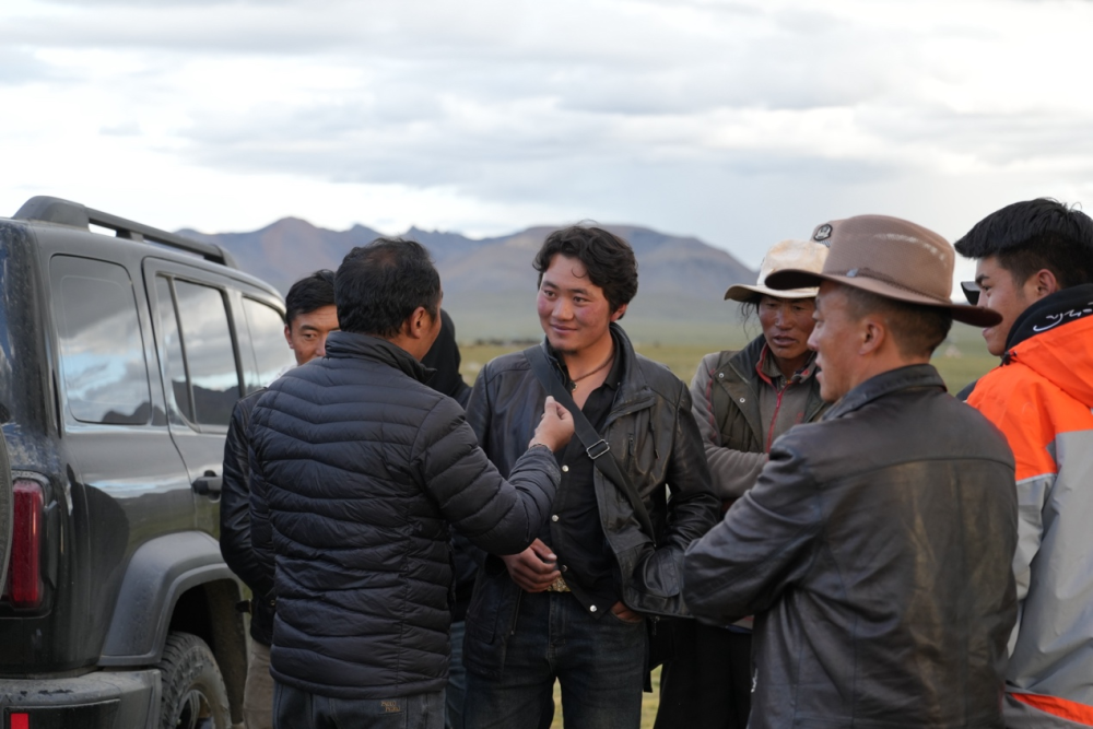 图为牧民向巴登求扎提问理赔标准。 何欣然摄