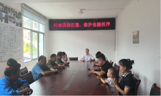 （图为：丹寨农商银行工作人员向村民讲解反洗钱知识）