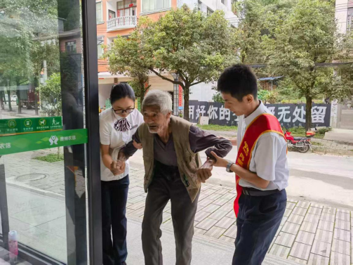 （图为：丹寨农商银行工作人员协助老人办理业务）
