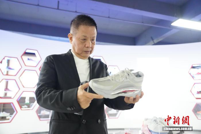 　　台商黄永坚在检查其工厂生产的鞋类产品。　中新社记者 张俊 摄