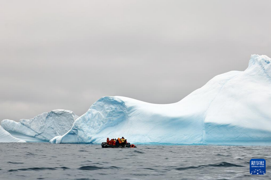 12月16日，探险者在南极洲拍摄海岸附近的冰山。新华社发（杨树摄）