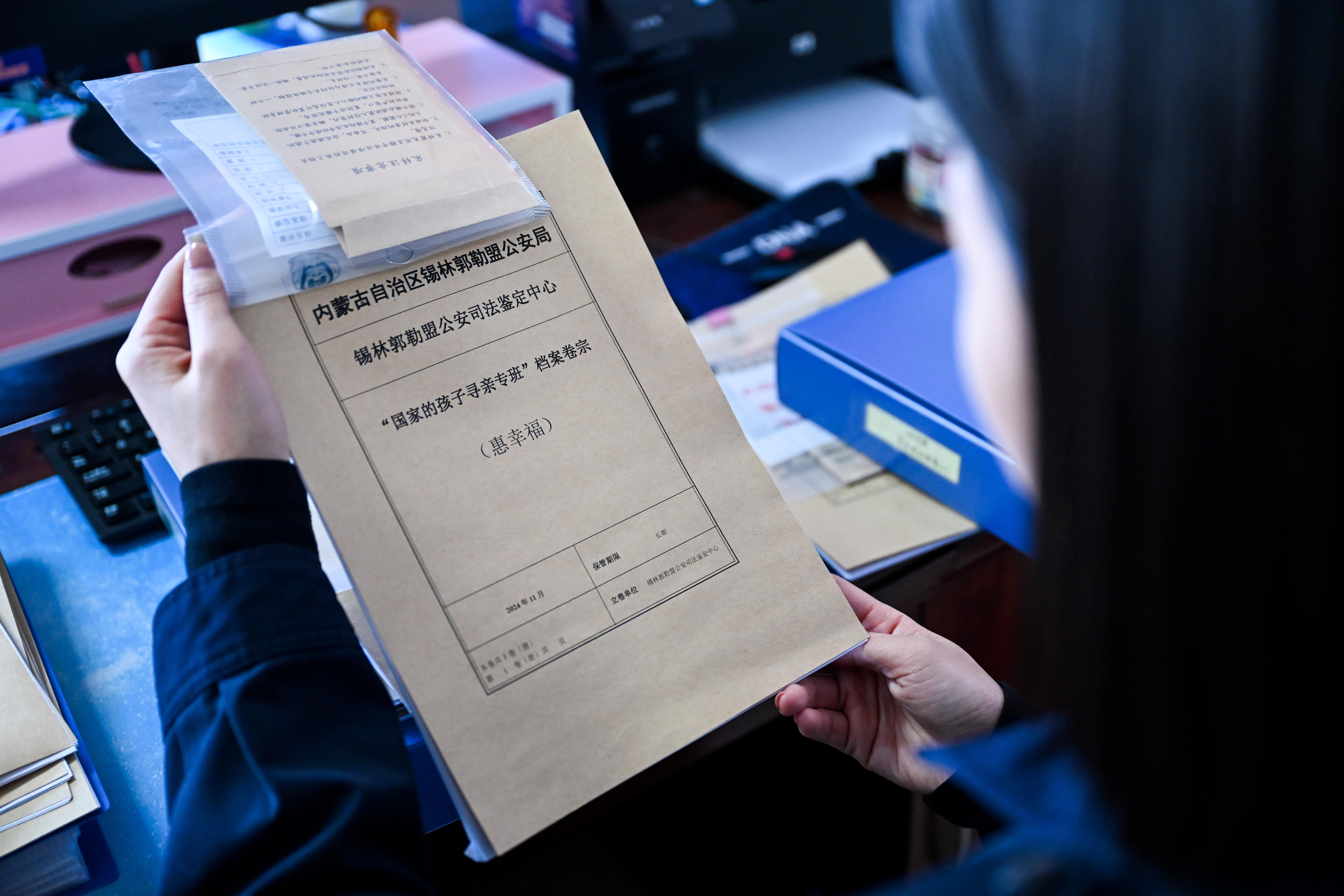 1月7日，孙志敏在锡林郭勒盟公安局整理“国家的孩子”寻亲档案。