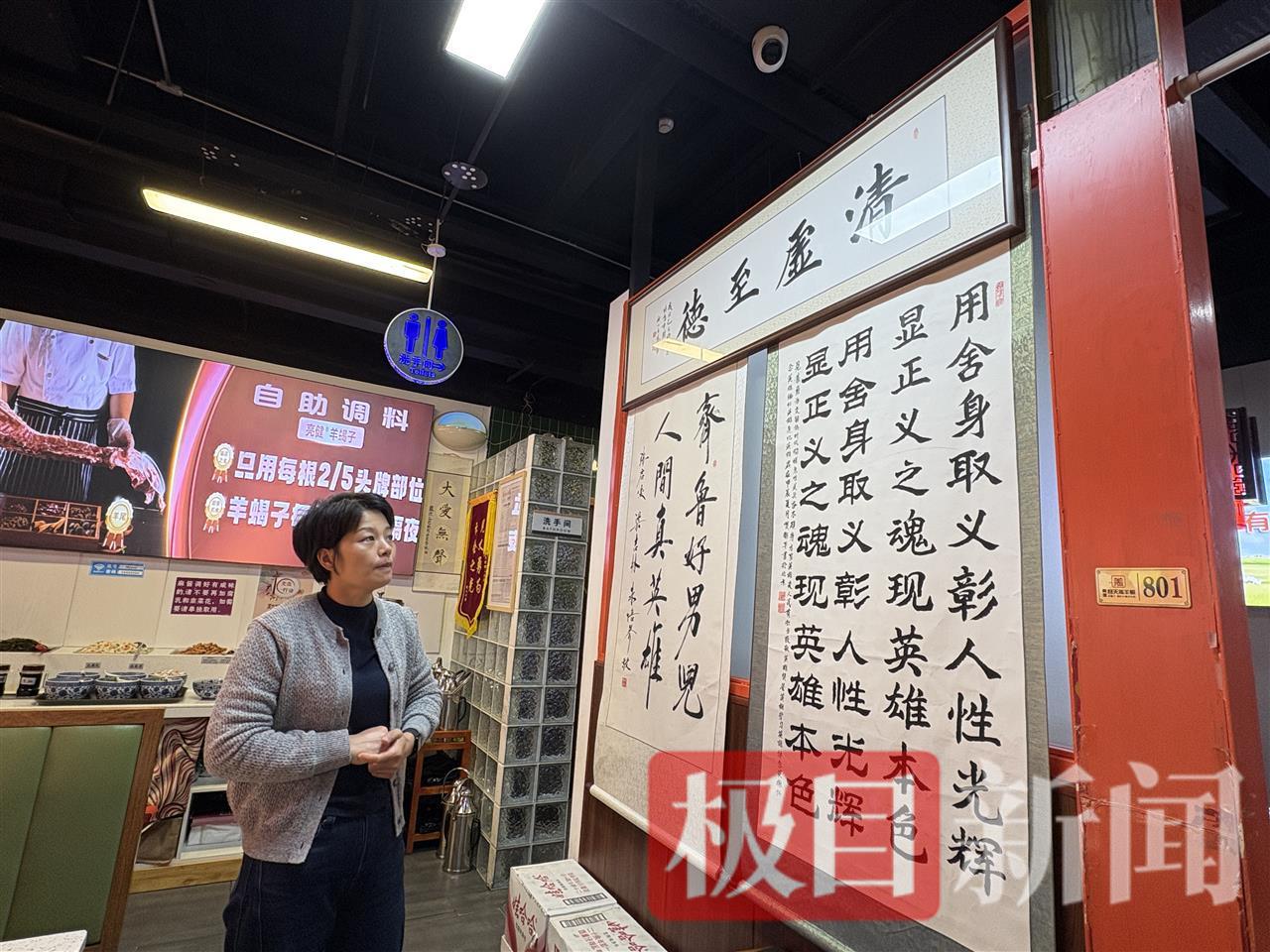 薛巧艳在一一介绍陌生网友送到店里的锦旗和题字（图源：记者拍摄）