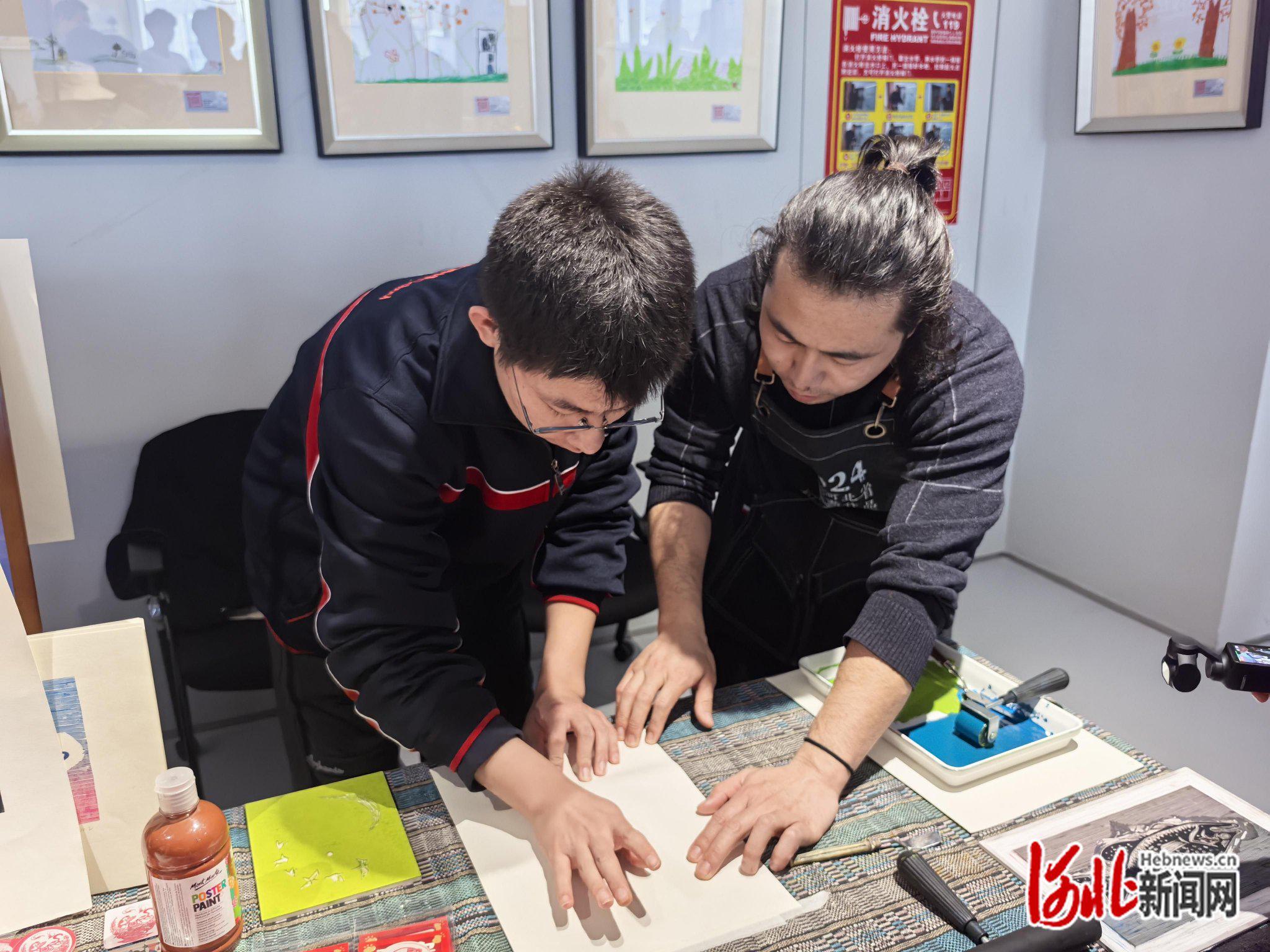 王钢强指导市民体验版画制作。赵家琪摄