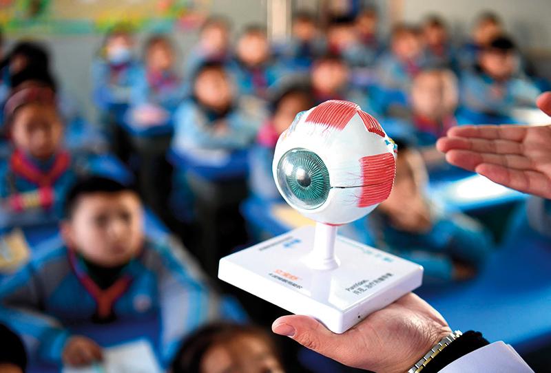 在石家庄市槐安西路小学，医务人员给学生们讲解眼睛的构造（资料照片） 王晓摄 / 本刊