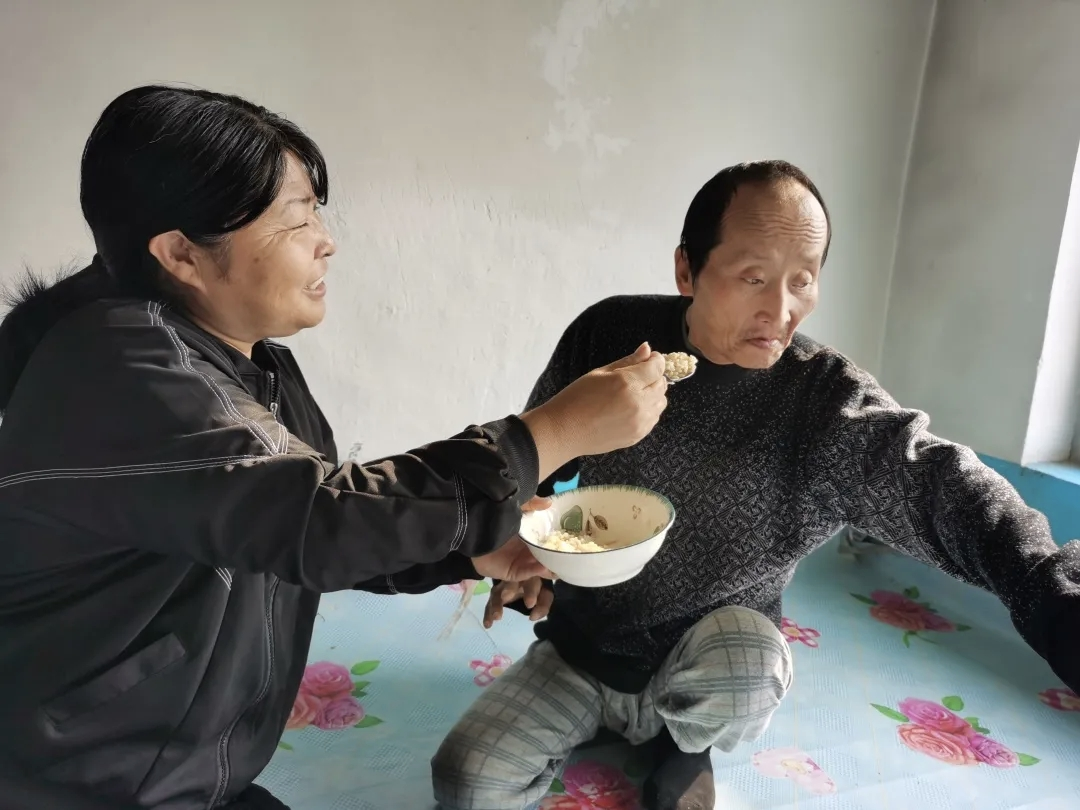 黄爱茹正悉心喂大伯哥赵静文吃饭。