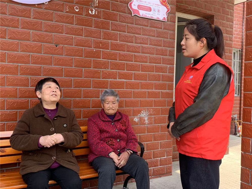 邰露露（右一）正在向居民进行政策宣讲。