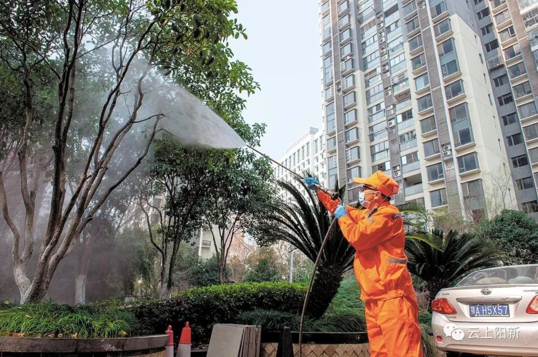 环卫工人在江汉区鑫城国际小区内喷洒消毒药.