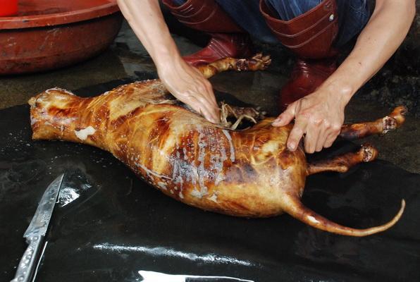 经过稻草大火焚烧,狗皮被烤为诱人的金黄色,散发出诱人的肉香及馑人